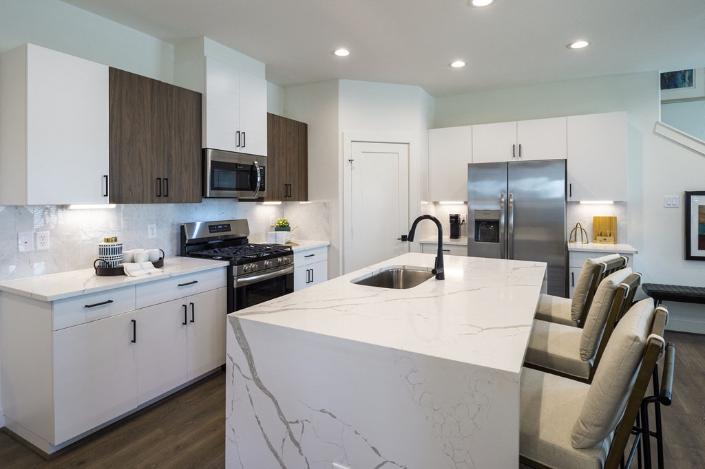 an open kitchen with a large marble counter top and a sink