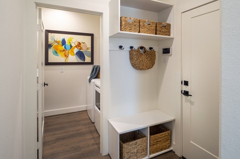 a small laundry room with baskets and baskets on the wall