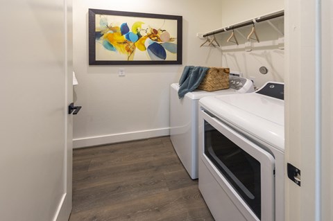 a laundry room with a washer and dryer and a painting on the wall