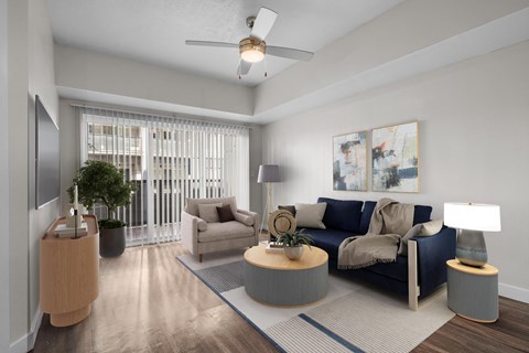 A living room with a blue couch and a ceiling fan.