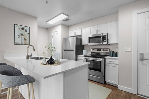 A modern kitchen with white cabinets and stainless steel appliances.