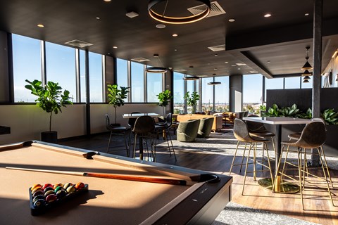 a lounge area with a pool table and tables and chairs