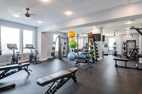 a fitness room with exercise equipment and large windows