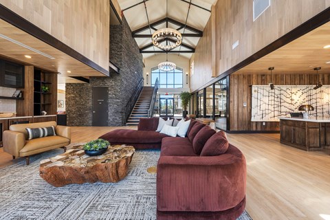 A living room with a red couch and a wooden coffee table.