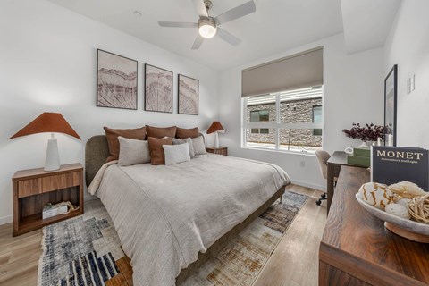 A bedroom with a large bed and a ceiling fan.
