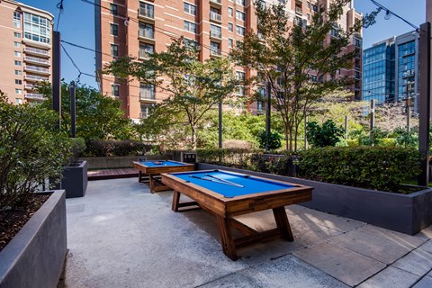 A pool table in a courtyard surrounded by buildings.