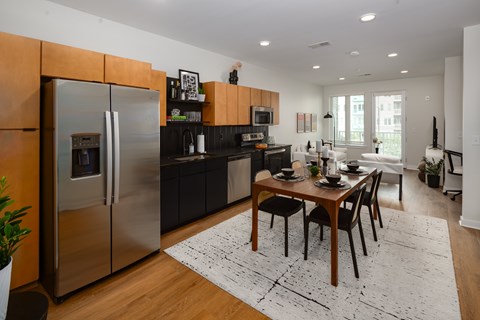 A modern kitchen with a dining table set for two.