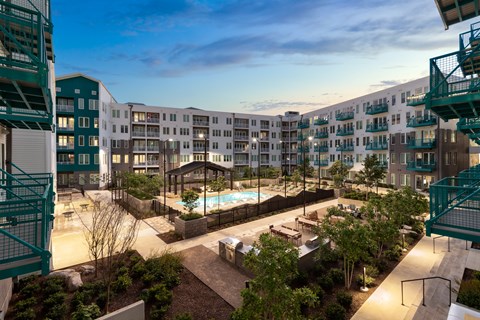 A view of a pool and patio area of a residential building.