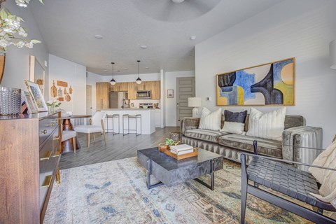 A living room with a couch, a coffee table, and a painting on the wall.
