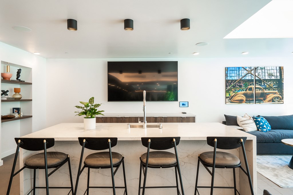 a view of the kitchen and living room of a house with white walls and a large white