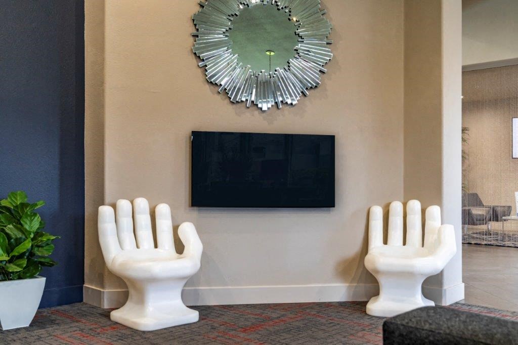 two large white toilets sitting next to a wall with a television