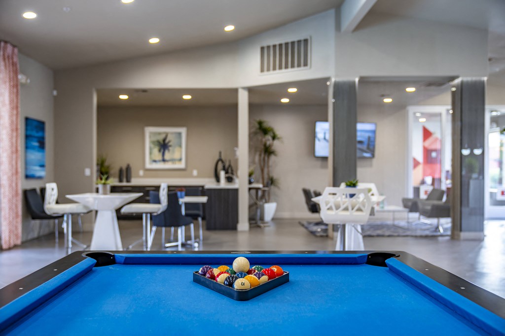 a games room with a pool table and tables