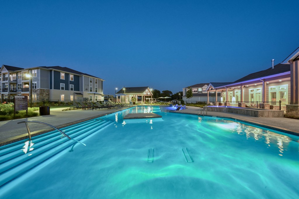 a large swimming pool with apartments in the background