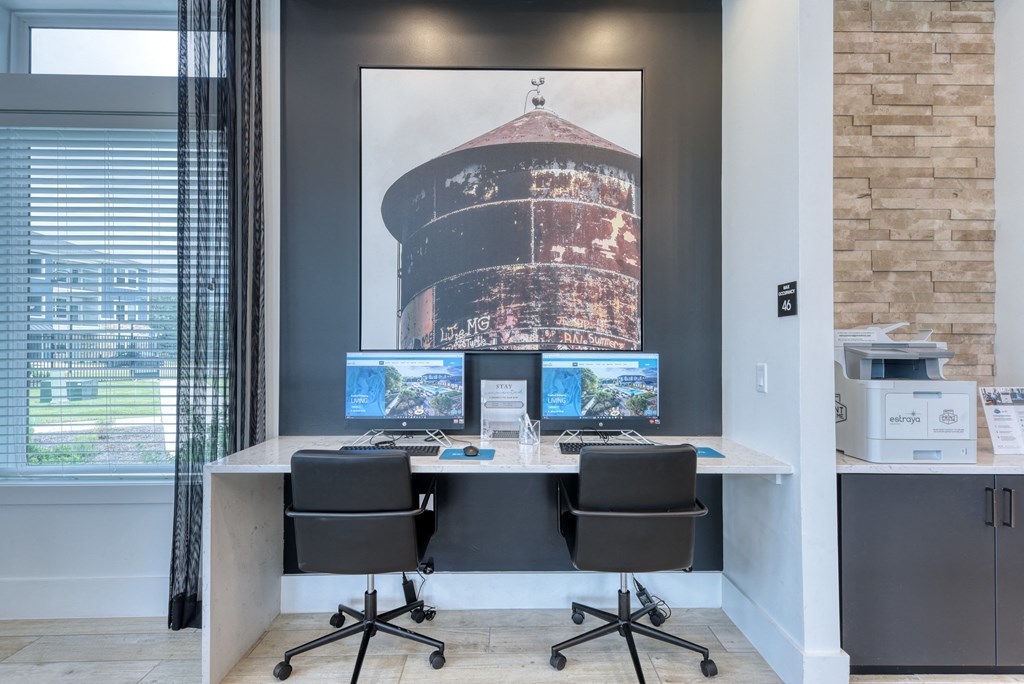 a desk with three computer monitors and a printer