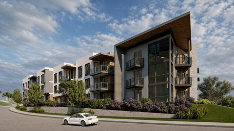 A white car is parked in front of a modern apartment building.