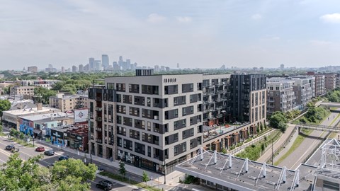 A modern multi-story building with a parking structure in front of it.