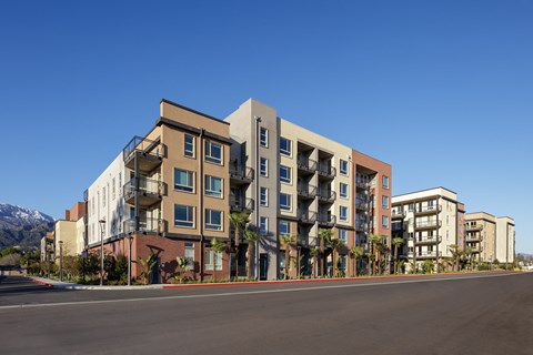 a rendering of a large apartment building with balconies and a street in front of it
