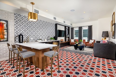 A modern kitchen with a bar and a dining table with chairs.