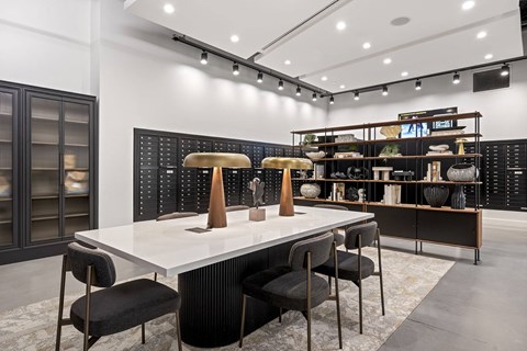 A modern dining room with a white table and black chairs.