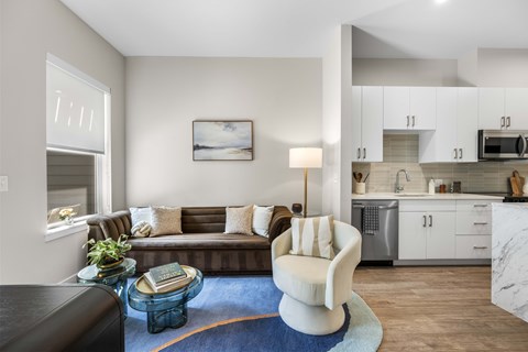 A modern living room with a brown couch and a white chair.