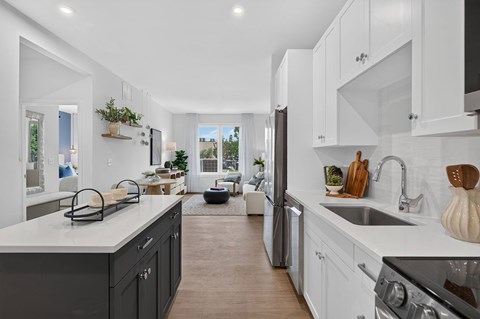 A modern kitchen with a large island and stainless steel appliances.