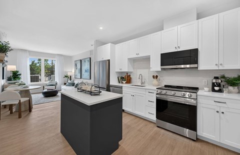 A modern kitchen with white cabinets and a black island.