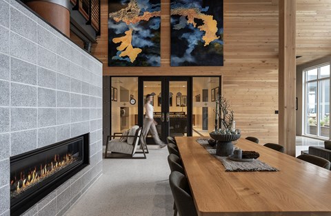 A person walks through a doorway into a room with a fireplace.