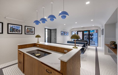 A modern kitchen with a white countertop and wooden cabinets.