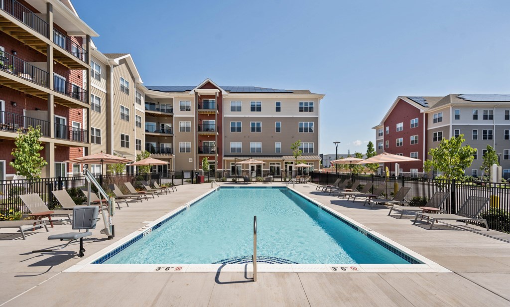 a swimming pool with an apartment building in the background