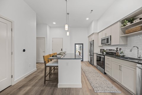 A modern kitchen with a dining table and chairs.