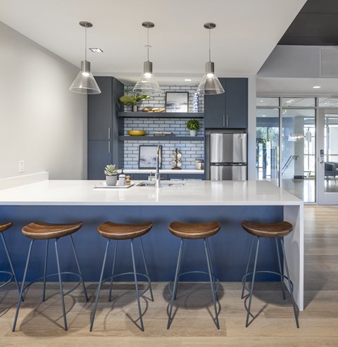 a kitchen with a blue counter top and three stools