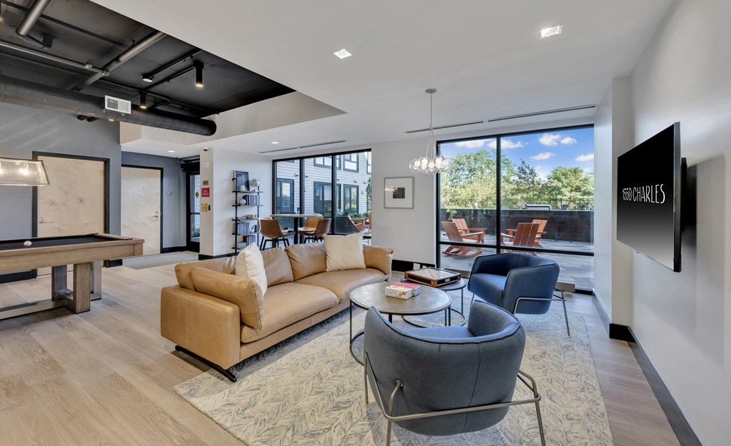 Community lounge area with plush seating, billiards table, board games, and entertainment kitchen