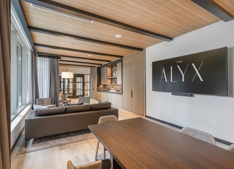 a conference room with a table and chairs and a tv on the wall