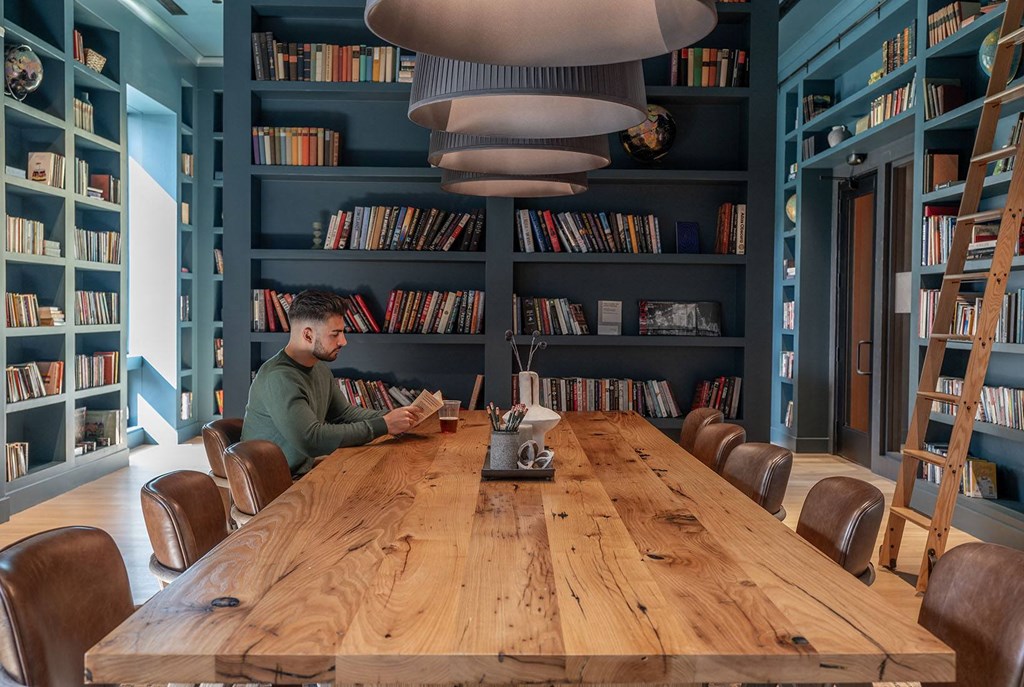 a man sitting at a wooden table in a library