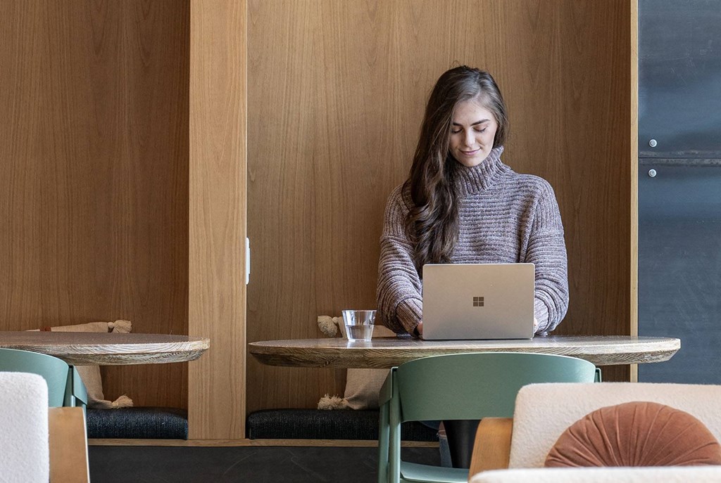 a woman sitting at a table with a laptop