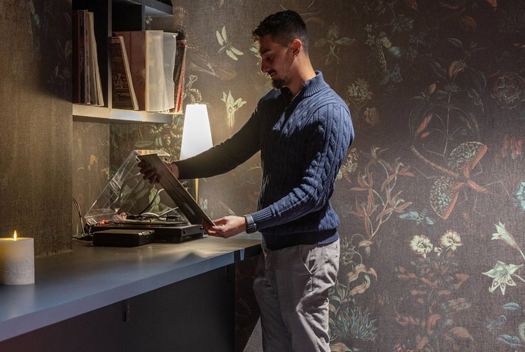a man standing at a kitchen counter using a pan