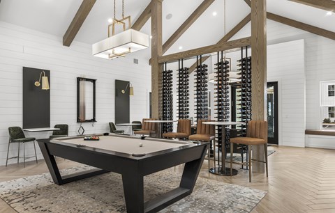 A pool table is in the middle of a room with a white brick wall and a mirror.