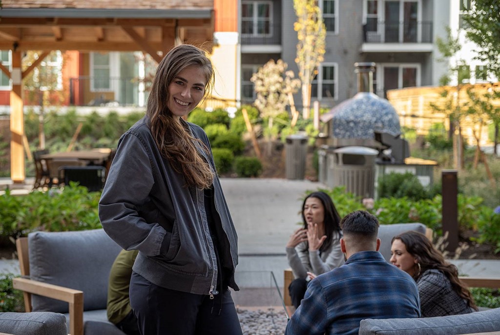 a woman standing in front of a group of people talking