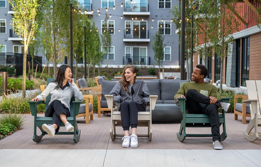a group of people sitting in chairs in a courtyard
