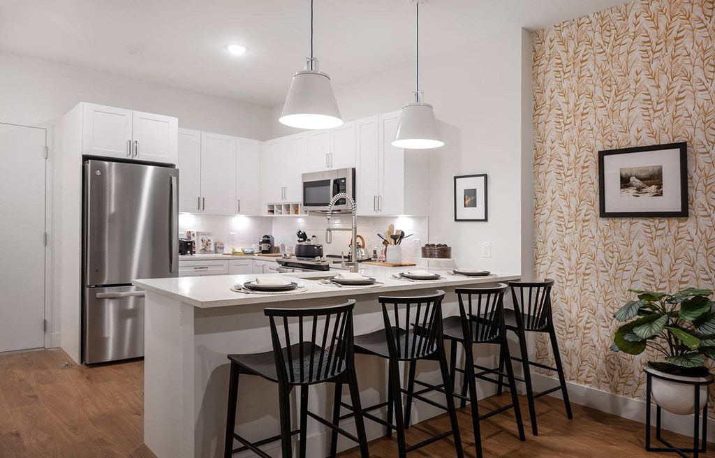 a kitchen with a center island and three chairs