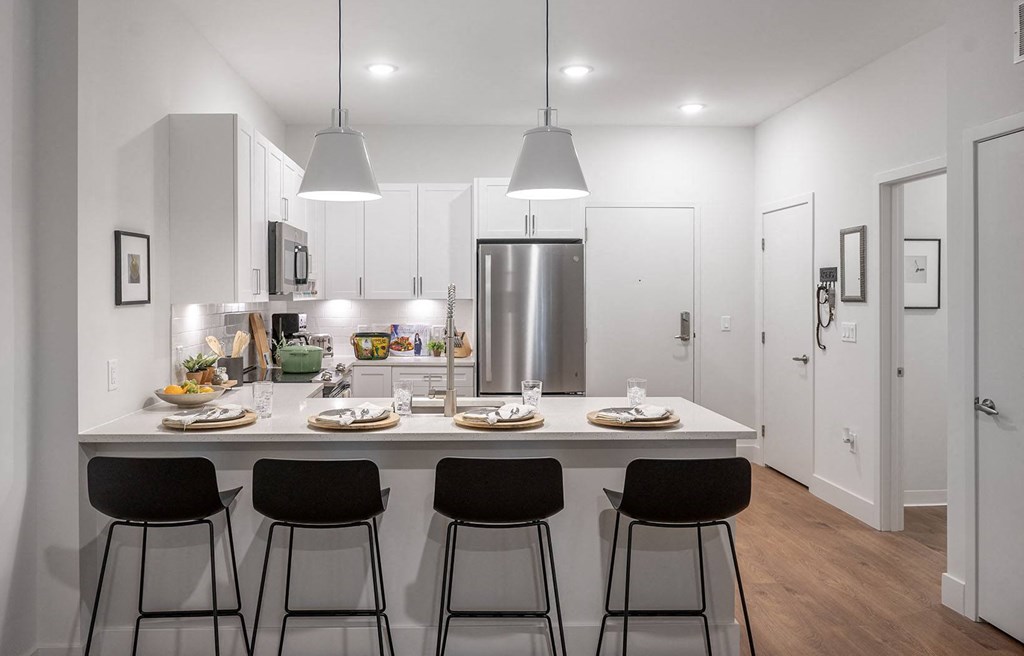 a kitchen with a counter top with four stools