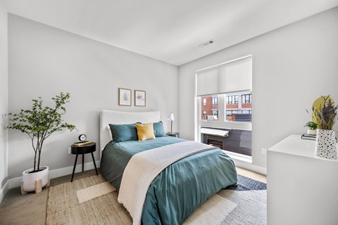 a bedroom with a medium sized bed and a large window