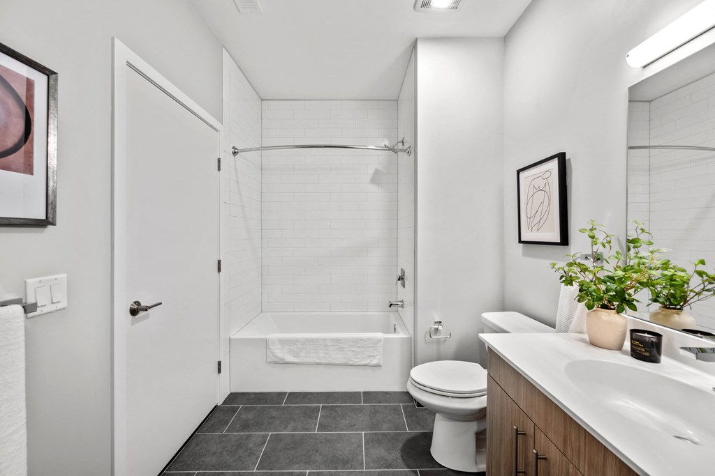 a bathroom with a toilet sink and shower in a model apartment bathroom