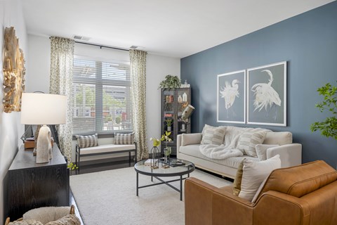 A living room with a white couch, a brown leather chair, and a coffee table.
