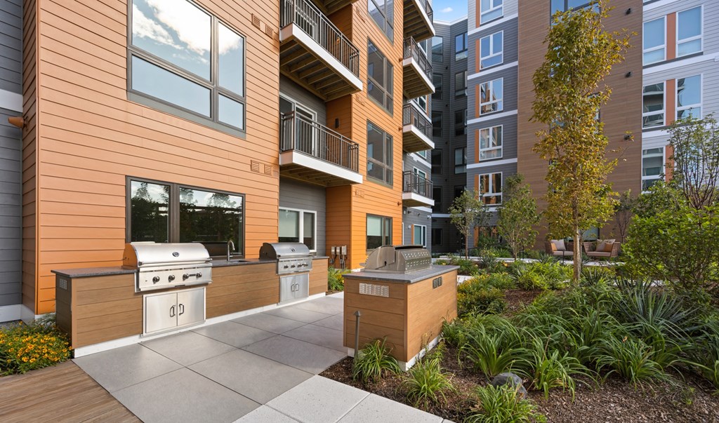 a courtyard patio with a grill and a barbecue in front of a building