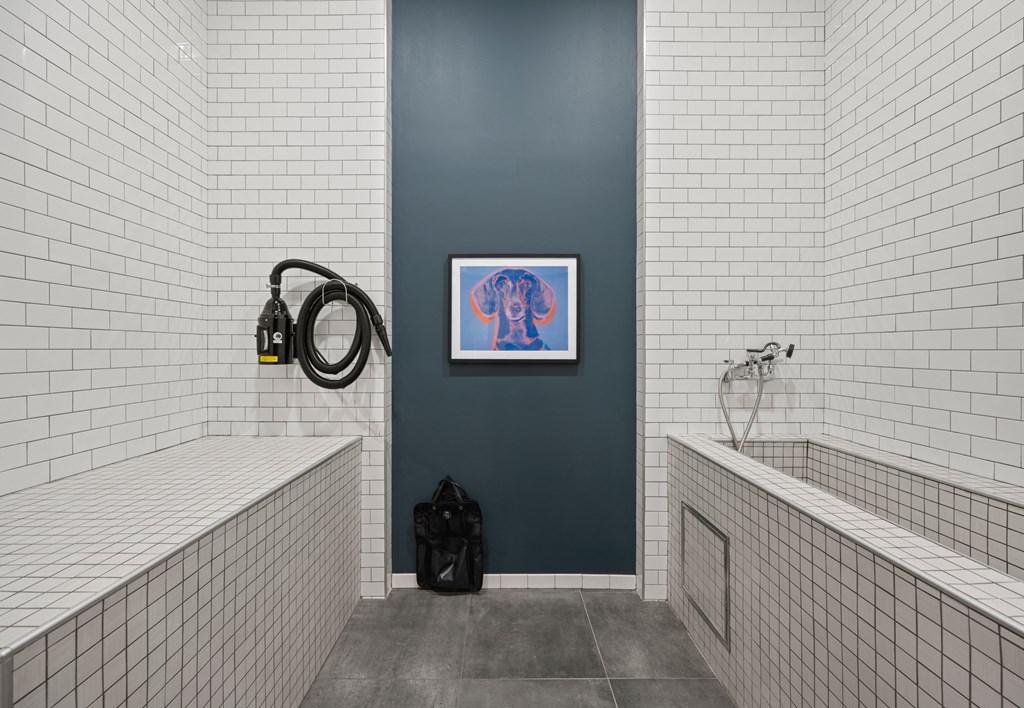 a bathroom with white subway tiles and a blue wall and a tub and a sink