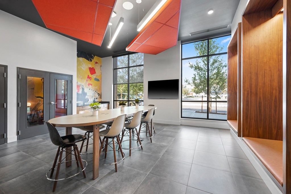 a conference room with a long table and chairs in front of a window