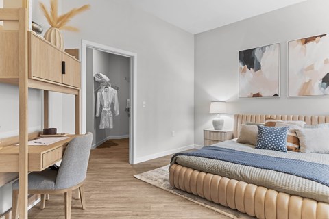 A bedroom with a large bed and a desk with a chair.