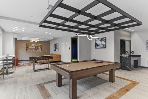 A pool table is in the middle of a room with a wooden floor.