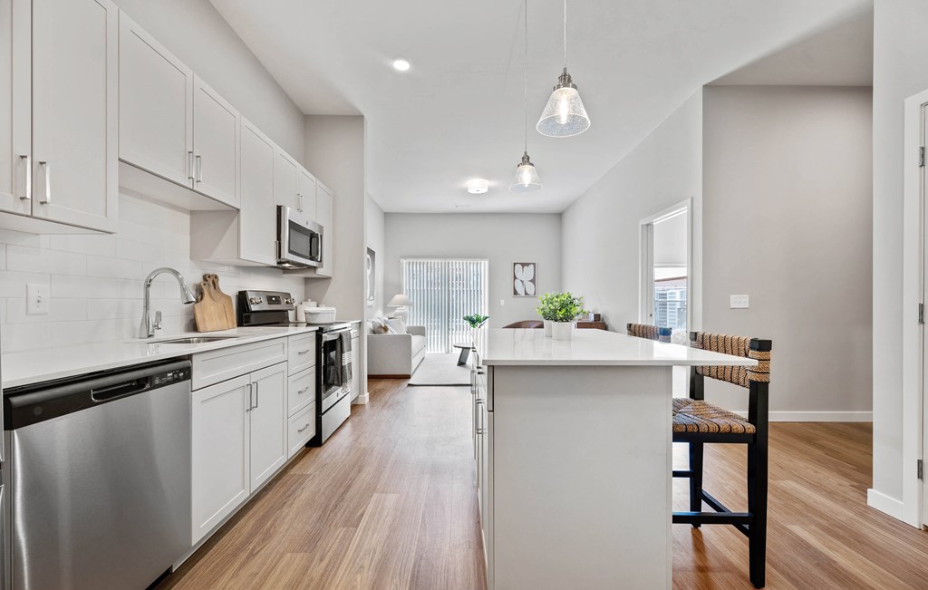 an open kitchen with white cabinets and a white counter top